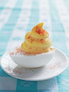 a small bowl filled with food sitting on top of a blue and white checkered table cloth