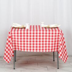 a red and white checkered table cloth with two cups on it