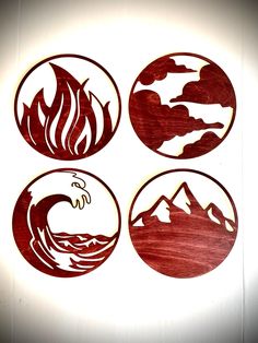 four circular wood cutouts with mountains and waves in them on a white wall background