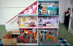 a doll house with lots of furniture and accessories on the floor in front of it