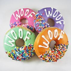 four donuts with sprinkles that say woof woof on them