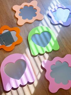 several different shaped mirrors sitting on top of a wooden floor