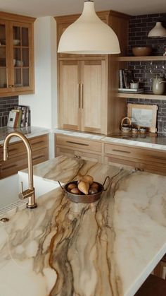 a kitchen with marble counter tops and wooden cabinets