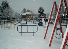 a snowy playground with swings and slides