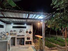 an outdoor kitchen is lit up at night