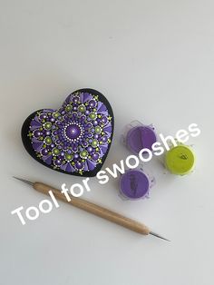 a heart shaped box sitting next to two markers and a pencil on a white surface