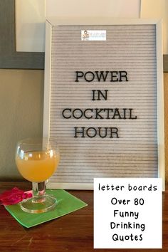 a sign that says power in cocktail hour next to a glass with orange juice on it