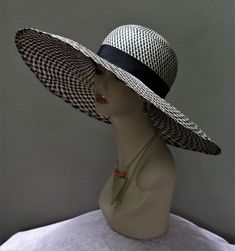 New women's Large Brim with rounded crown Hat by Alexander & Hallatt in Natural Cream and Black Geometric woven pattern Buntal straw with black Petersham band (inside and outside). Statement piece.  Please note that Alexander & Hallatt strive to produce the highest quality hats and fascinator headbands. With care, this fascinator can last a long time. Also note that there will be imperfections, like a stich showing or a line which is not perfect, but this adds to the charm of a true one-of a kin Beach Boater Hat With Structured Crown, Adjustable Woven Hat With Structured Crown, Summer Sun Hat With Structured Crown, Black Brimmed Woven Panama Hat, Black Structured Crown Hat For Summer, Black Woven Panama Hat With Flat Brim, Black Woven Flat Brim Panama Hat, Black Woven Brimmed Panama Hat, Black Woven Panama Hat With Short Brim