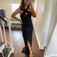 a woman in a black dress taking a selfie