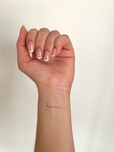 a woman's arm with a small heartbeat tattoo on it