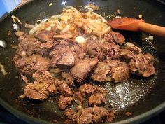 meat and onions cooking in a wok on the stove