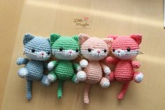 three crocheted cats sitting next to each other on a wooden surface with the caption kitty friends