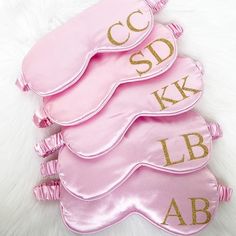 three pink and gold sleep masks with the letters'sdk, lb, ab'written on them