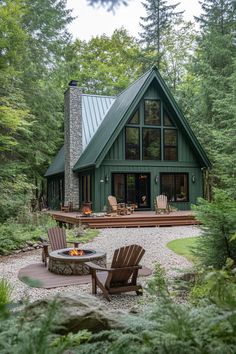 a small cabin in the woods with two chairs and a fire pit on the patio