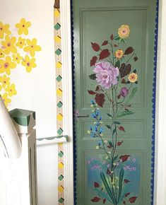 a green door with flowers painted on it