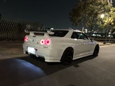 a white car parked on the street at night