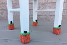 two crocheted carrots sitting on top of white stools