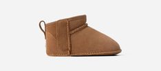 This Classic Ultra Mini has all the features of our full-size Classics, including our iconic suede upper and UGG®plush upcycled wool blend in the lining and insole for our signature comfy and cushioned feel. Hook-and-loop closures on the side make it easier to put on and take off. This style is available in sizes for the whole family. | Suede upper. Pull tab. Hook-and-loop closure. 10mm UGG®plush 60% upcycled wool, 40% TENCEL Lyocell lining. 10mm UGG®plush 60% upcycled wool, 40% TENCEL Lyocell insole. Molded rubber outsole. Woven heel label with UGG® logo. RN 88276. | UGG® Infants' Classic Ultra Mini Suede Classic Boots in Chestnut, Size 6-12 mos Baby Highlights, Mens Ascot, Baby Uggs, Ugg Classic Ultra Mini, Baby Boots, Ugg Classic, Classic Boots, Pull Tab, Chestnut