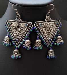 Stand out wearing these eye catching, fun and flirty triple jhumka Indian earrings, in oxidized silver with colorful dangly beads. Hand crafted. Excellent quality and craftsmanship. Nicely detailed triangular center with sparkly small glass inserts at each corner. Comfortable to wear. Height: 3 1/2 in Width: 2 1/2 in Weight: 17 gm Shop more earrings here: https://www.etsy.com/shop/boutiquebymaryam?section_id=22797814 Shop BoutiqueByMaryam: https://www.etsy.com/shop/boutiquebymaryam All my jewelr Bohemian Bell Earrings For Festivals, Bohemian Festival Earrings With Bells, Handmade Danglers For Navratri Festival, Bohemian Festival Jhumkas Dangle Earrings, Bohemian Dangle Jhumkas For Festival, Bohemian Drop Jhumkas For Festivals, Bohemian Multicolor Earrings For Navratri, Bohemian Festival Dangle Jhumkas, Bohemian Metal Danglers For Party