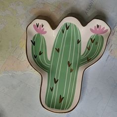 a plate with a cactus on it sitting on a table next to a world map