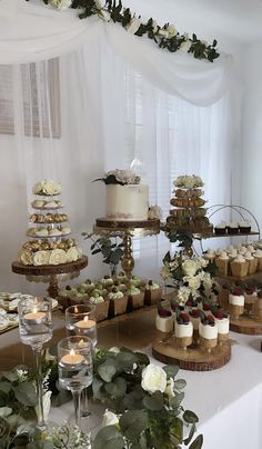 a table filled with cakes and cupcakes covered in frosting