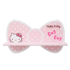 a pink hello kitty bow shaped shelf with polka dots on the front and bottom half