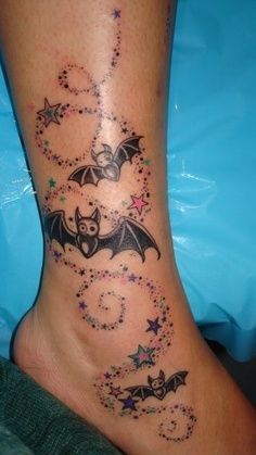 an image of a bat tattoo on someone's foot with stars and bats all over it