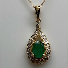 Set Securely In The Center Of The Pendant A Natural Emerald Gemstone. The Emerald Measures 7 X 5mm And Weighs Approximately 0.80 Carats. It Has A Medium Green Color With Only Natural Inclusions. The Gemstone Is Surrounded By A Yellow Gold Braided Detail And Then A Full Row Of Small White Diamonds. The Diamonds Are Set In A Scalloped Halo Design. The Total Diamond Weight Is 0.10ct Twt. There Is A Large High Polished Bail At The Top That Allows The Emerald And Diamond Pendant To Swing Freely. It M Emerald Pendant Necklace 1stdibs, Emerald Beads Jewelry Indian Pendant, Classic Oval Emerald Necklace In Yellow Gold, Oval Diamond For May Birthstone, Classic Yellow Gold Oval Emerald Necklace, Oval Diamond Cut Emerald Necklace Fine Jewelry, Oval Diamond Cut Emerald Necklace, Oval Diamond Cut Emerald Necklace For Anniversary, Classic Oval Emerald Necklace With Prong Setting