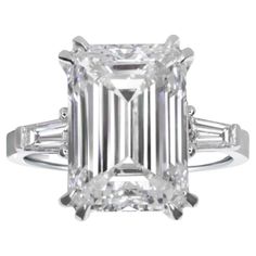 Indulge in the allure of sophistication with this captivating ring, where a magnificent 5-carat emerald-cut diamond takes center stage. The G color and VVS2 clarity of the diamond contribute to its exceptional brilliance and purity, making it a testament to refined elegance. Flanking the stunning emerald-cut diamond are two tapered baguette diamonds, adding a touch of modernity to the timeless design. These diamonds, with their sleek and elongated profile, perfectly complement the central gem, creating a harmonious ensemble of classic and contemporary elements. Set in a lustrous 18K gold setting, this ring is a masterpiece of craftsmanship and luxury. The warm tones of the gold provide a rich backdrop for the diamonds, enhancing their sparkle and creating a piece that exudes both opulence Estate Diamond Jewelry, Rare Diamond, Emerald Cut Diamond Ring, Three Stone Diamond Ring, Platinum Diamond Rings, Modern Engagement Rings, Three Stone Diamond, Emerald Cut Diamond, Modern Ring