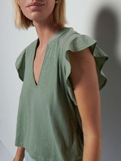 Because you love the Paulette tank, but want a little more romance. We get it. This top has a similar silhouette, now with a narrow V neck and relaxed ruffle sleeves for a softer feminine edge. Go ahead. Flirt back. (This one comes in Sea Spray.) | Women's Constance Tank Top in Sea Spray | Ethical Essentials Chic Summer Tops With Flutter Sleeves, Summer Relaxed Fit Flutter Sleeve Tops, Ruffle Sleeve Tops For Layering, Feminine Green Top With Flutter Sleeves, Feminine Green Flutter Sleeve Top, Feminine Green Tops With Flutter Sleeves, Spring Ruffle Sleeve Top For Layering, Chic Green Tops With Ruffle Sleeves, Ruffle Sleeve Tops For Summer Layering