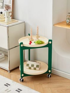 a green and white table sitting on top of a wooden floor