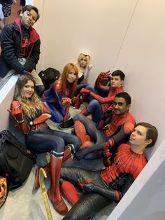 a group of people dressed as spider - man and woman sitting on the floor in an elevator