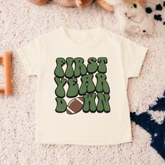 Football Birthday Shirt, Football First Birthday, First Birthday Shirt, Birthday Boy Shirt, First Birthday, Toddler Birthday Shirt  💗  Welcome to The WildflowerbyMiley Etsy Shop!  This listing is for the bodysuit, sweatshirt or t-shirt only. All other items that are shown in our photos such as shoes, hats, beanies, blankets etc. are for photo staging purposes and are NOT INCLUDED in the sale. DESCRIPTION:  This baby and children's unisex essential fits like a well-loved favorite. Super soft t-shirts, sweatshirts and baby bodysuits for your little lads and gals meant to showcase their big personalities. Its Excellent quality and vibrant print makes one fall in love with it over and over again.  This adorable piece is the perfect lightweight layer for casual wearing.  This product is hand p Green Graphic Print T-shirt For First Birthday, Green T-shirt With Letter Print For First Birthday, First Birthday Short Sleeve T-shirt With Text Print, First Birthday T-shirt With Text Print, Casual T-shirt With Number Print For First Birthday, Cotton Number Print T-shirt For Birthday, Short Sleeve T-shirt With Text Print For First Birthday, Cotton T-shirt With Number Print For Birthday, First Birthday Graphic Tee With Letter Print