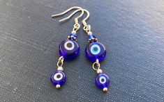 These are elegant earrings with Greek Evil Eye pendants. The hooks are stamped sterling silver (925). All parts are lead and nickel safe. The earrings will be sent in a lovely Red Cherry Gems gift box ready for gifting. If you have any questions, please do ask. The Greeks have used these blue Evil Eyes talismans to protect against the evil eye. The evil eye is a curse believed to be cast by a malevolent glare, usually given to a person when they are unaware. Many cultures believe that receiving Sterling Silver Dangle Evil Eye Jewelry, Blue Evil Eye Dangle Jewelry, Sterling Silver Evil Eye Dangle Earrings, Blue Evil Eye Dangle Earrings, Blue Sterling Silver Evil Eye Earrings, Silver Round Evil Eye Earrings, Blue Round Evil Eye Earrings, Greek Evil Eye, Evil Eyes