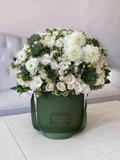 a bouquet of white flowers in a green bucket