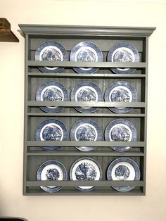 a shelf with plates on it in front of a wall