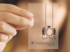 a woman holding up a clear business card with a camera on it's side