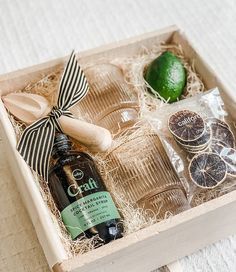 a wooden box filled with different types of food and drinks on top of a table