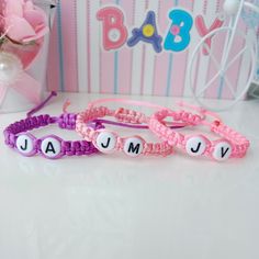 three bracelets with letters that spell out the word baby and v u m e