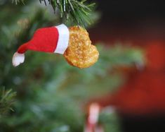 a christmas ornament hanging from a pine tree