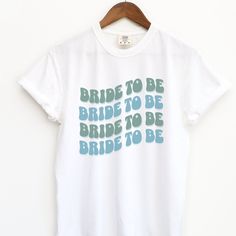 a white t - shirt with the words bride to be printed in blue on it