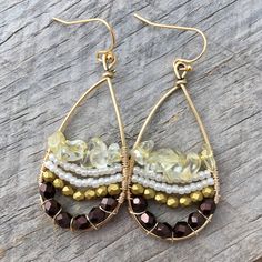 These fun earrings are made with a gold plated drop frame, tarnish-resistant gold plated copper wire, eggplant and gold faceted Czech glass beads, white Japanese seed beads, and citrine chip beads. The ear hooks are 14k gold-plated. These earrings measure 24x47mm and are lightweight. Colors do vary on different monitors; please keep this in mind. ~Care instructions: Not waterproof- do not wear while showering, swimming, etc. As with all jewelry, keep away from children and pets, and store in a d Wire Wrapped Czech Glass Drop Earrings, Handmade 14k Gold Filled Round Beaded Earrings, Bohemian 14k Gold-filled Beaded Earrings, Bohemian 14k Gold Filled Round Beaded Earrings, Bohemian Crystal Earrings With Faceted Beads For Gift, 14k Gold-filled Dangle Jewelry With Gold Beads, Bohemian Beaded 14k Gold Filled Earrings, Unique Gold Crystal Drop Earrings, Gold Beads Metal Drop Earrings