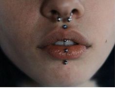 a woman's nose with piercings on it