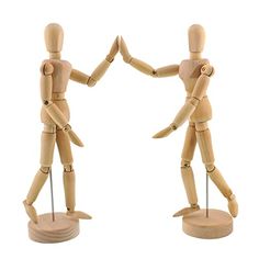 two wooden mannequins holding hands with each other