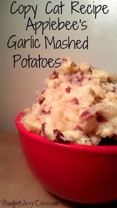 a red bowl filled with mashed potatoes on top of a table