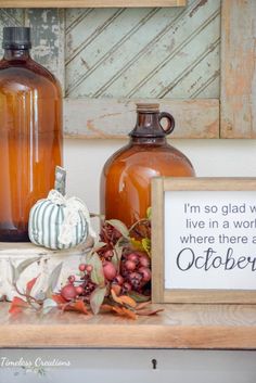 a shelf with two vases and a sign on it that says i'm so glad to live in a world where there are october