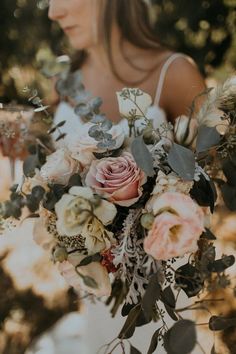 a woman holding a bouquet of flowers in her hands