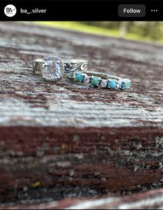 two rings with turquoise stones on them sitting on top of a wooden table next to each other