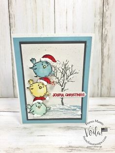 a christmas card with two cats and a bird in the snow, on top of a table