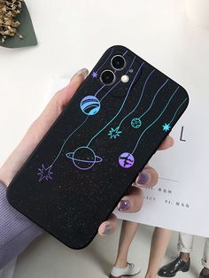 a person holding up a phone case with space drawings on it